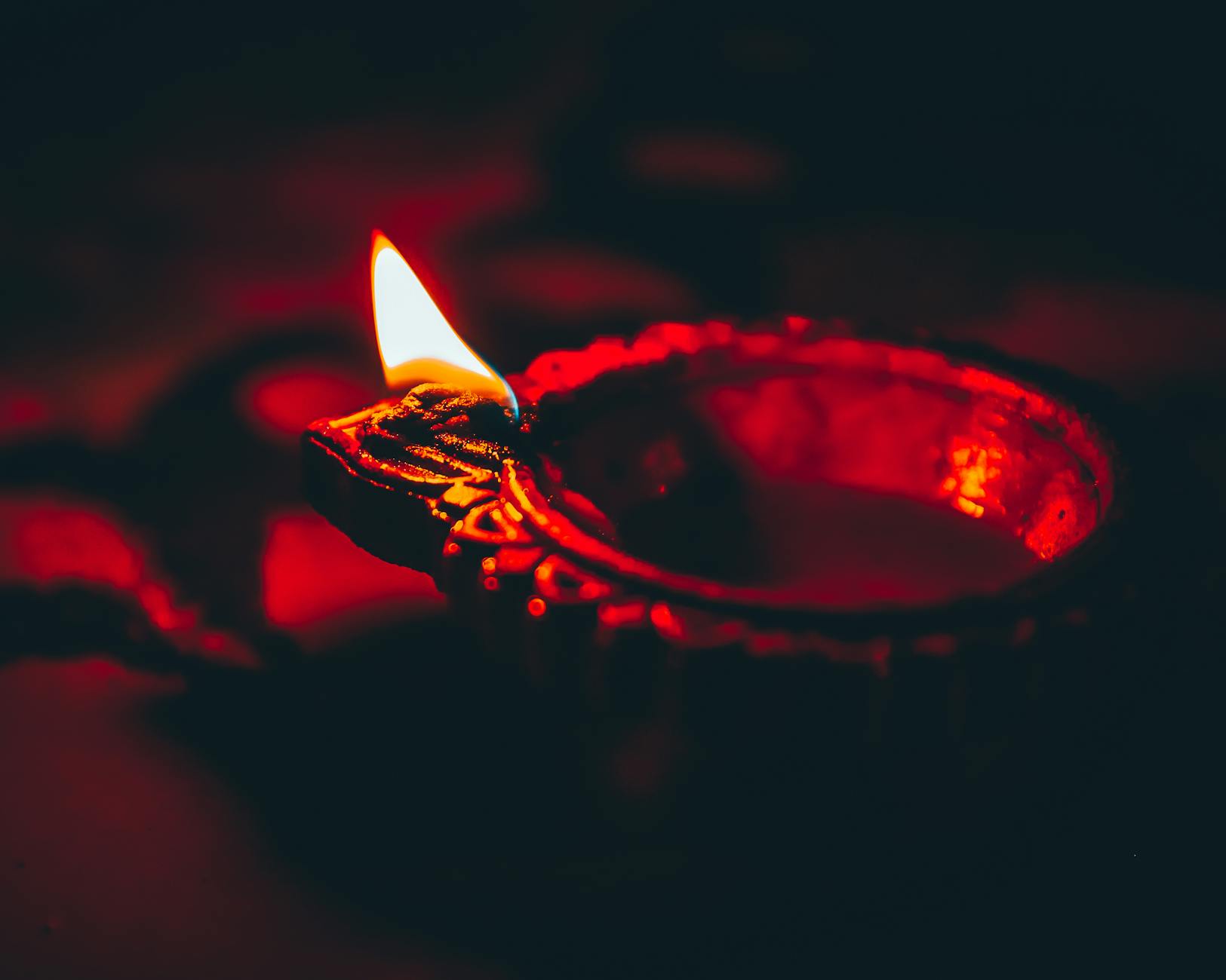 diya burning on table in darkness